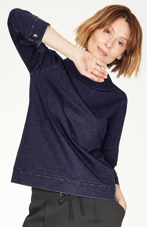Navy Blue denim sweatshirt in simple shape, with feminine ties at the sleeves and a relaxed funnel neck.