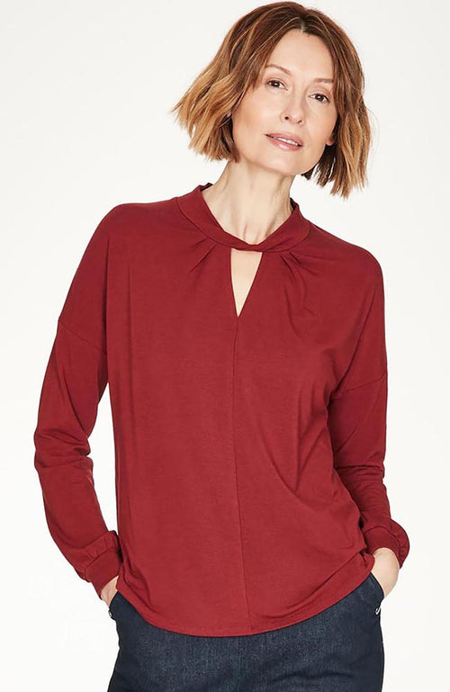 Ruby Red top with twist neck slit detail and long cuffed sleeves.